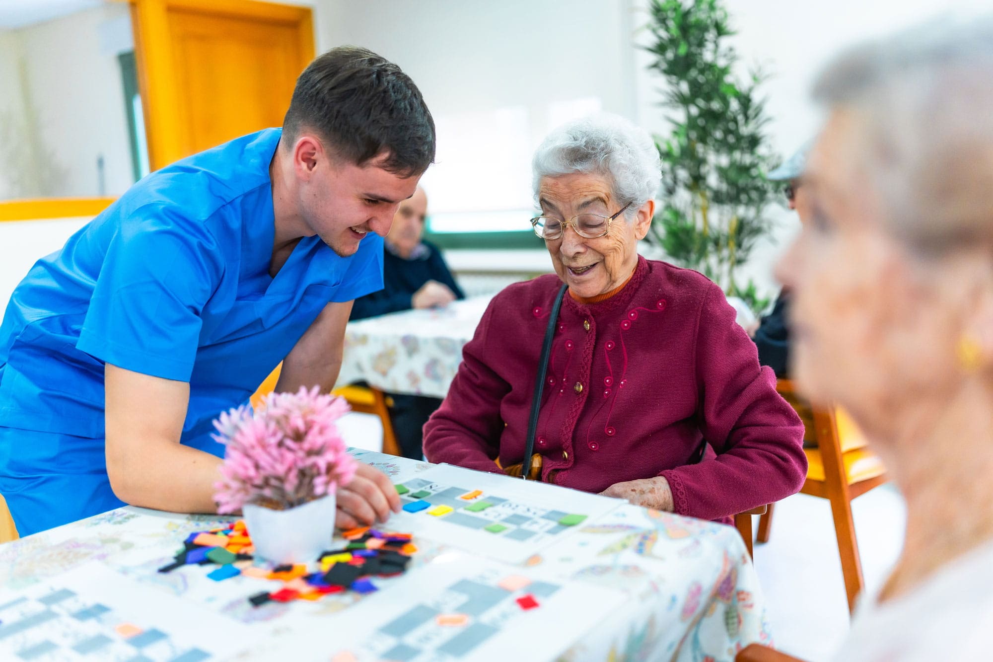 Pflegepersonal begleitet Senior beim sicheren Gehen zu Hause