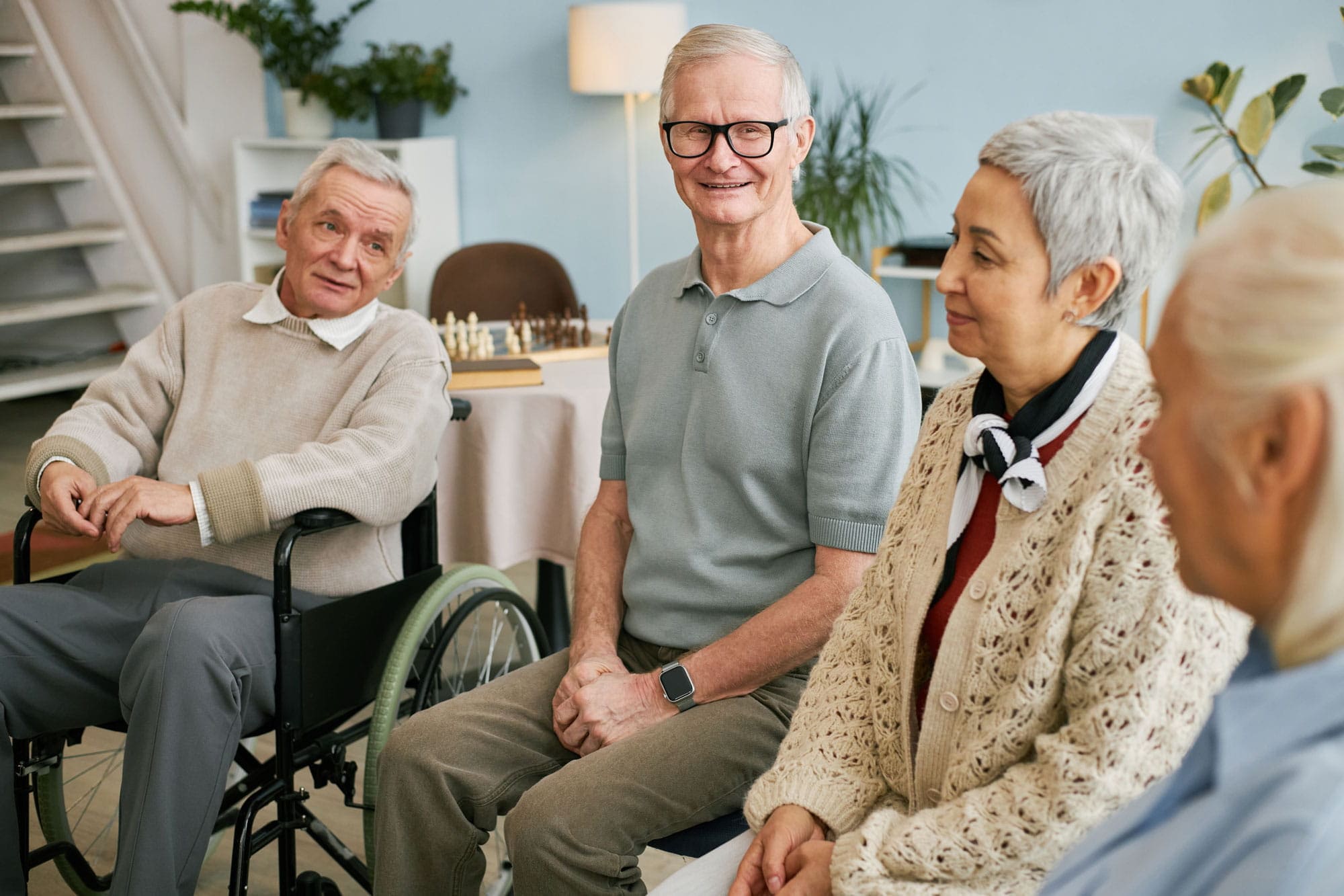 Senior wird beim Hinsetzen und Aufstehen unterstützt